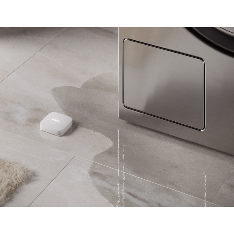 Ajax LeaksProtect placed near washing machine to detect a water leak